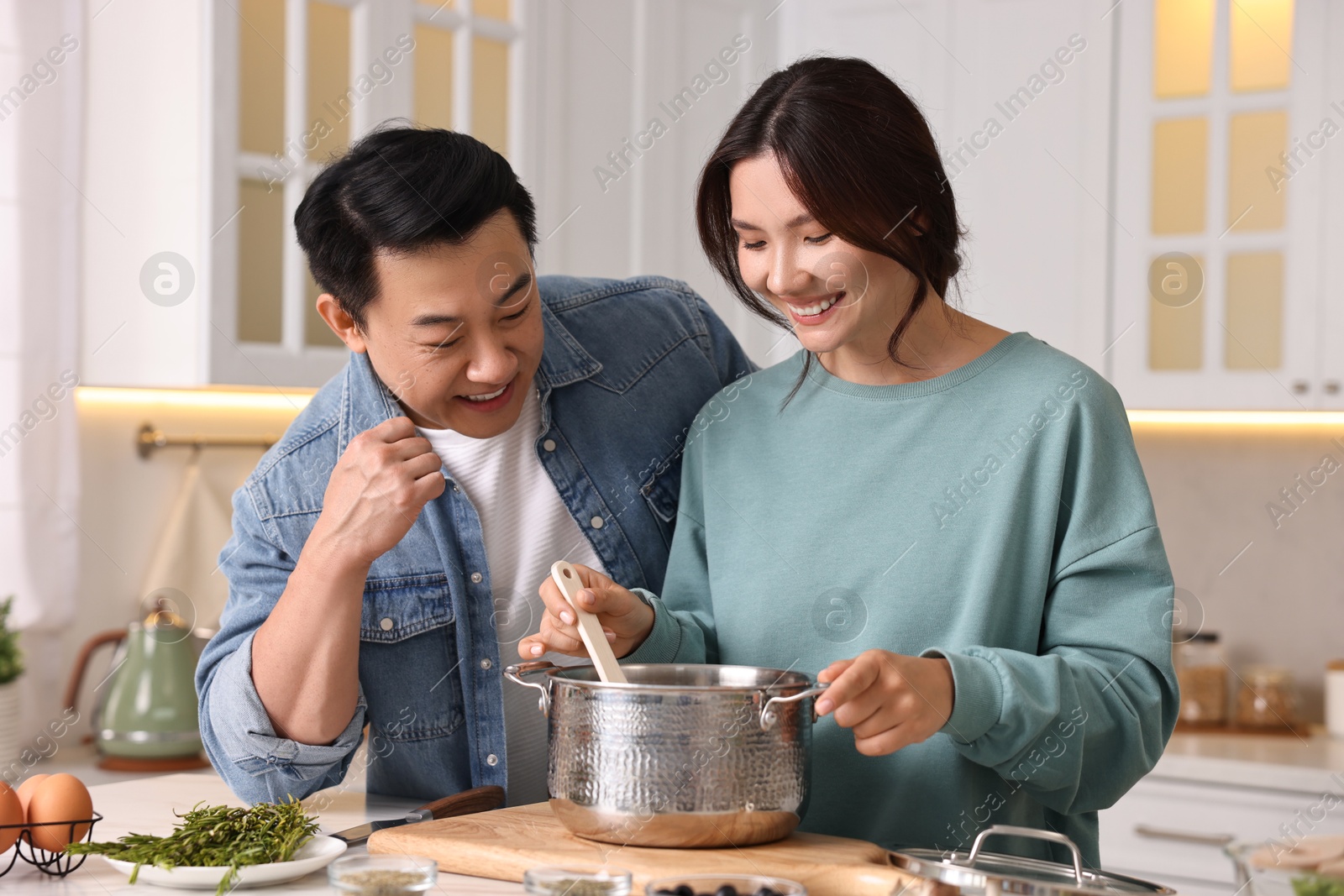 Photo of Happy lovely couple cooking together in kitchen