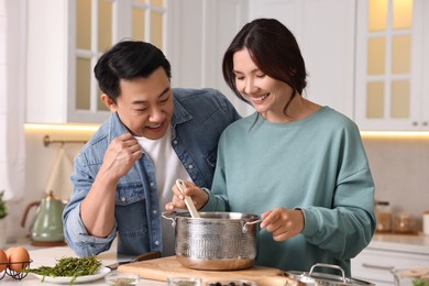 Happy lovely couple cooking together in kitchen