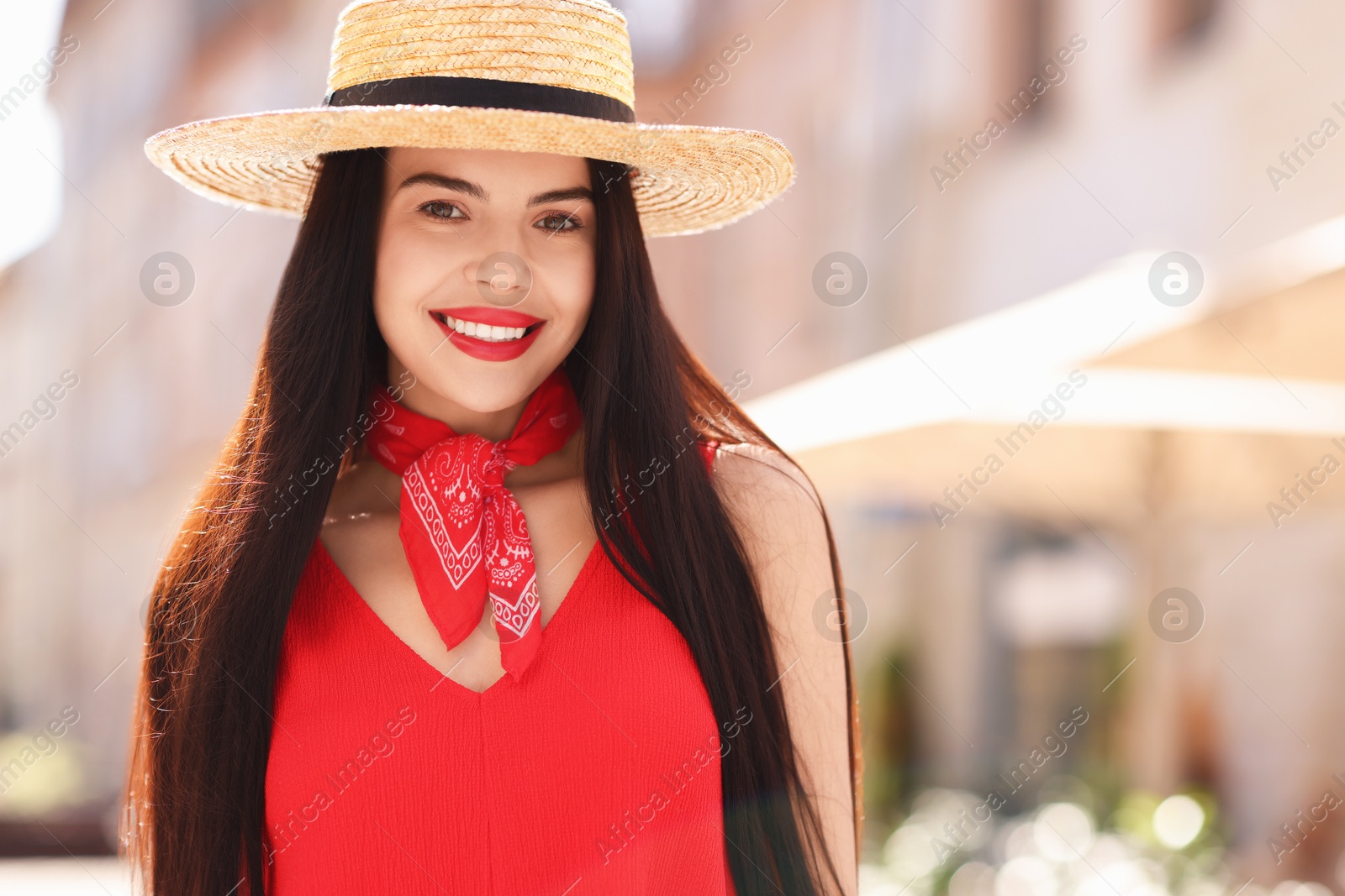 Photo of Beautiful young woman in stylish hat on city street, space for text