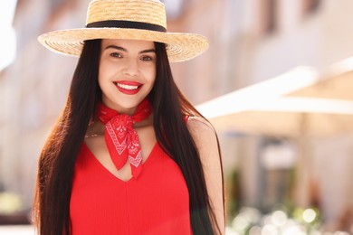 Beautiful young woman in stylish hat on city street, space for text