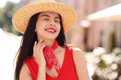 Beautiful young woman in stylish hat on city street