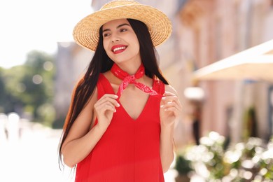 Beautiful young woman in stylish hat on city street