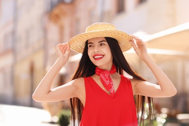 Beautiful young woman in stylish hat on city street