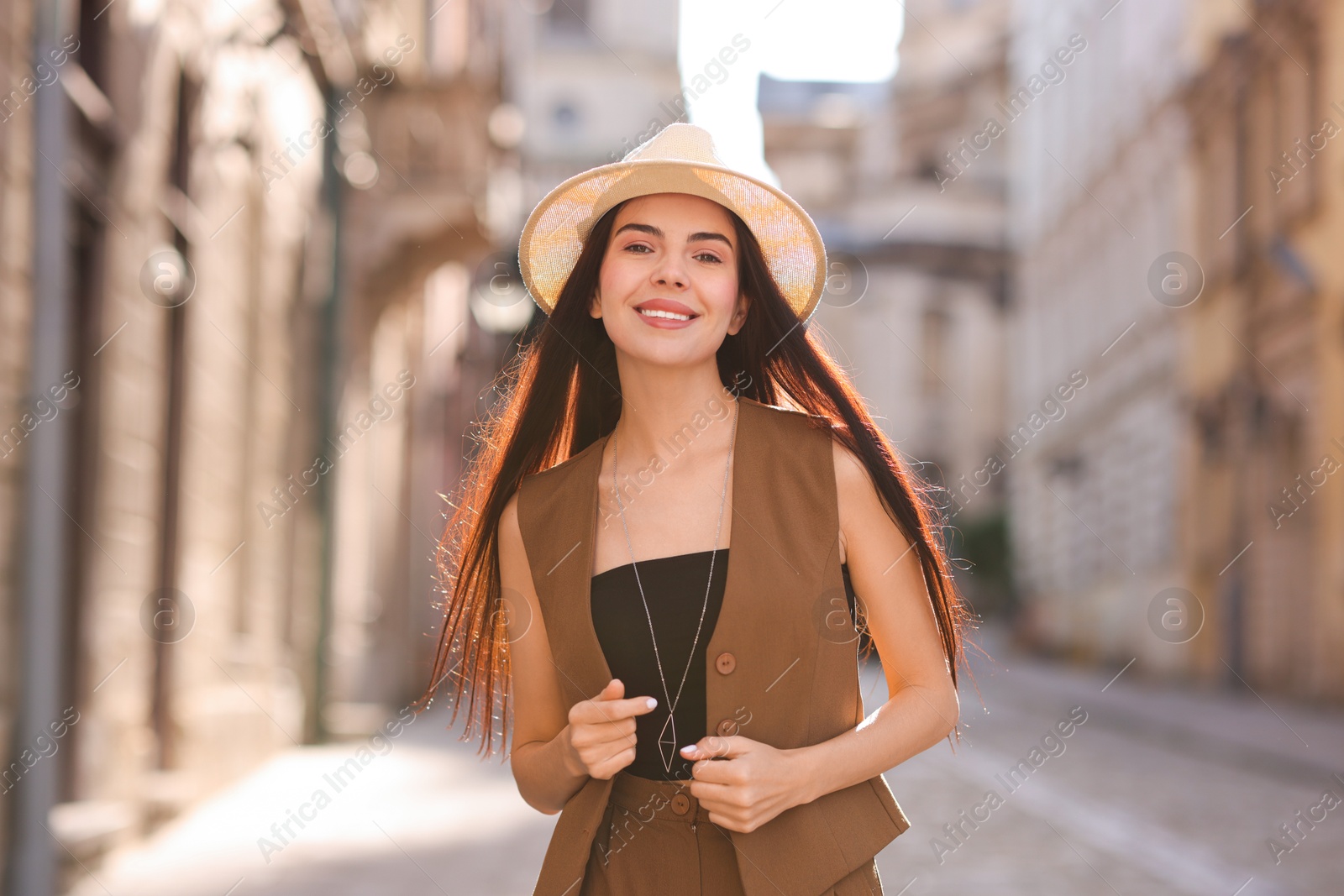 Photo of Beautiful young woman in stylish hat on city street