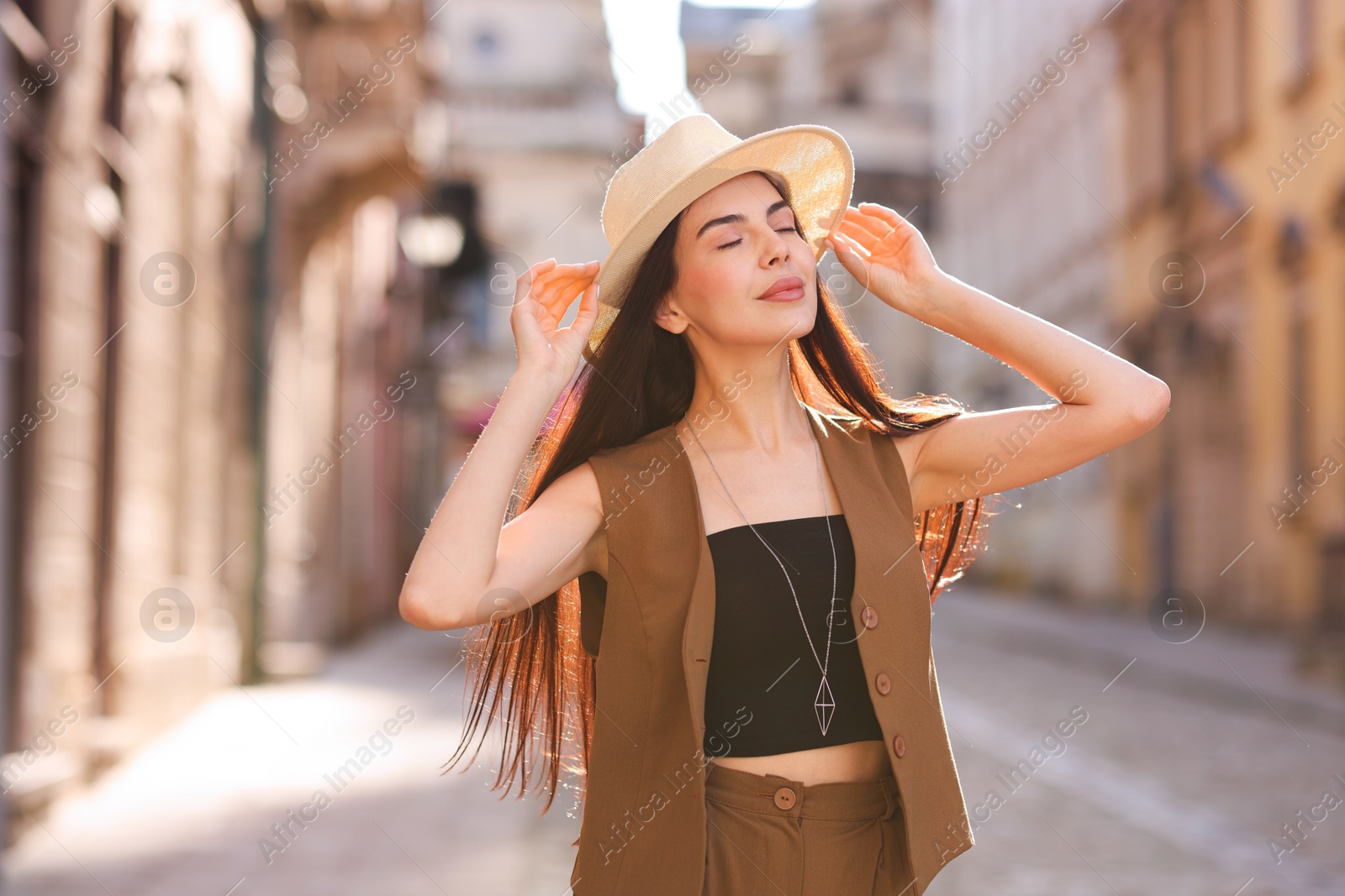 Photo of Beautiful young woman in stylish hat on city street