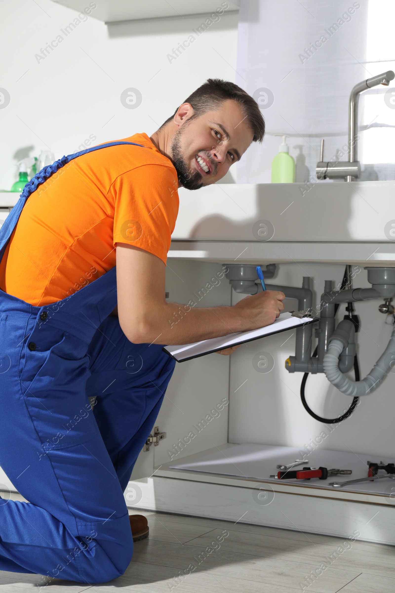 Photo of Professional plumber fixing piping system at home