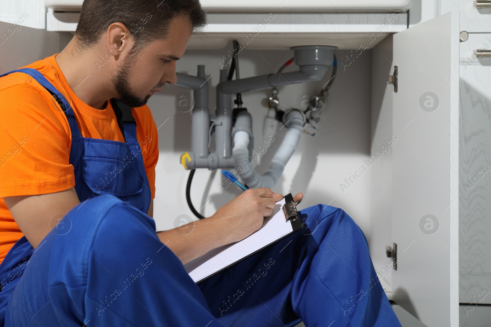 Photo of Professional plumber fixing piping system at home