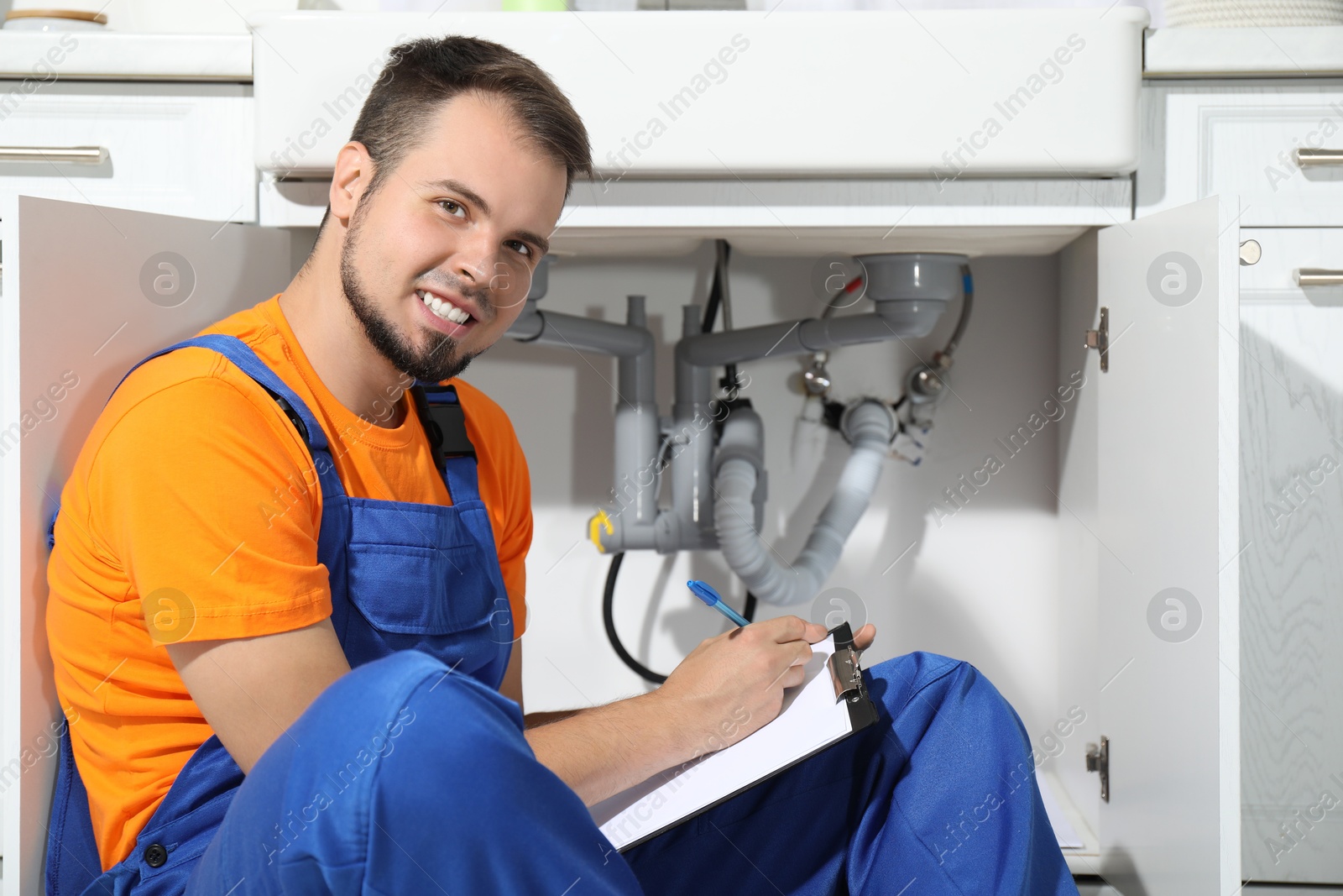 Photo of Professional plumber fixing piping system at home