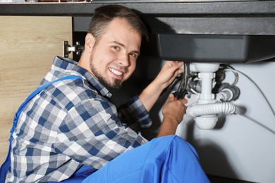 Professional plumber fixing piping system at home