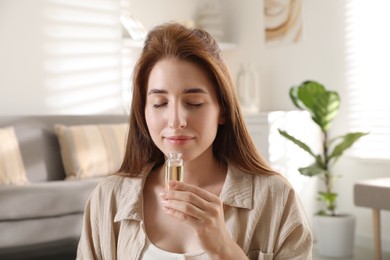 Woman with bottle of essential oil at home