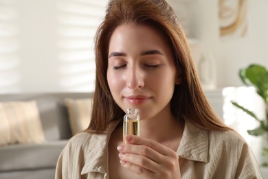 Woman with bottle of essential oil at home