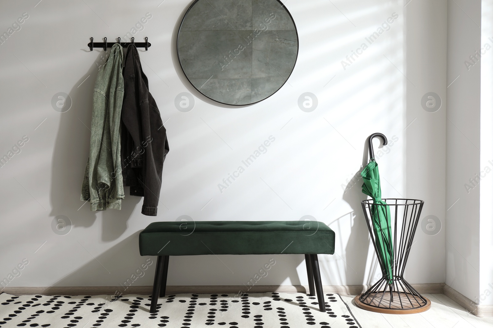 Photo of Green umbrella in stand near light wall