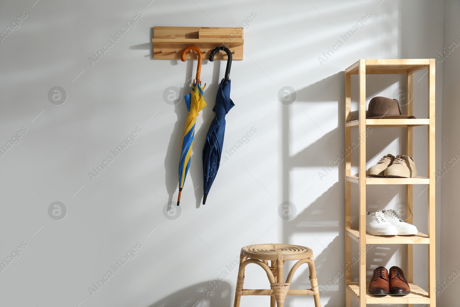 Photo of Colorful umbrellas hanging on rack at home