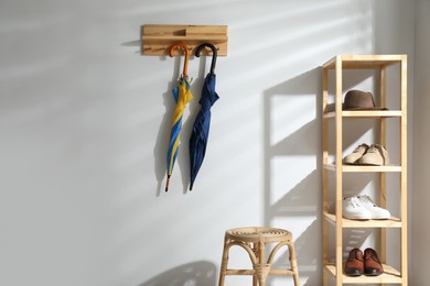 Colorful umbrellas hanging on rack at home