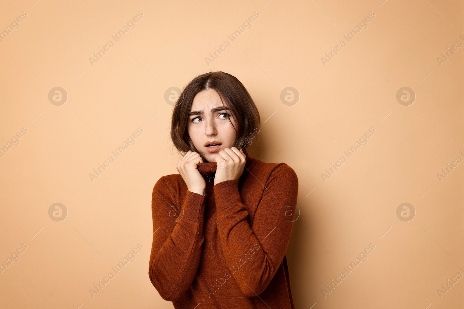 Photo of Portrait of scared woman on beige background