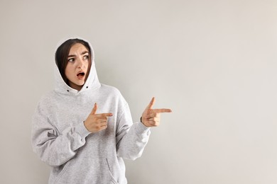 Portrait of scared woman on light background. Space for text