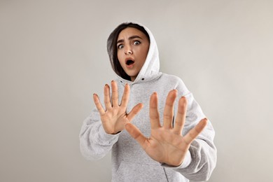 Portrait of scared woman on light background