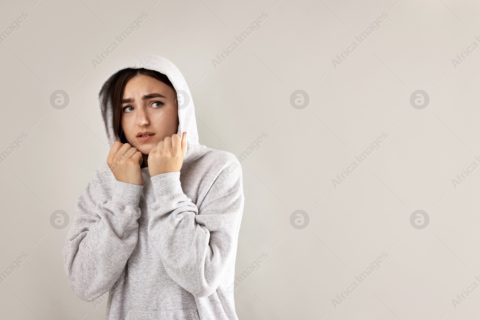 Photo of Portrait of scared woman on light background. Space for text