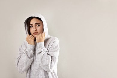 Photo of Portrait of scared woman on light background. Space for text