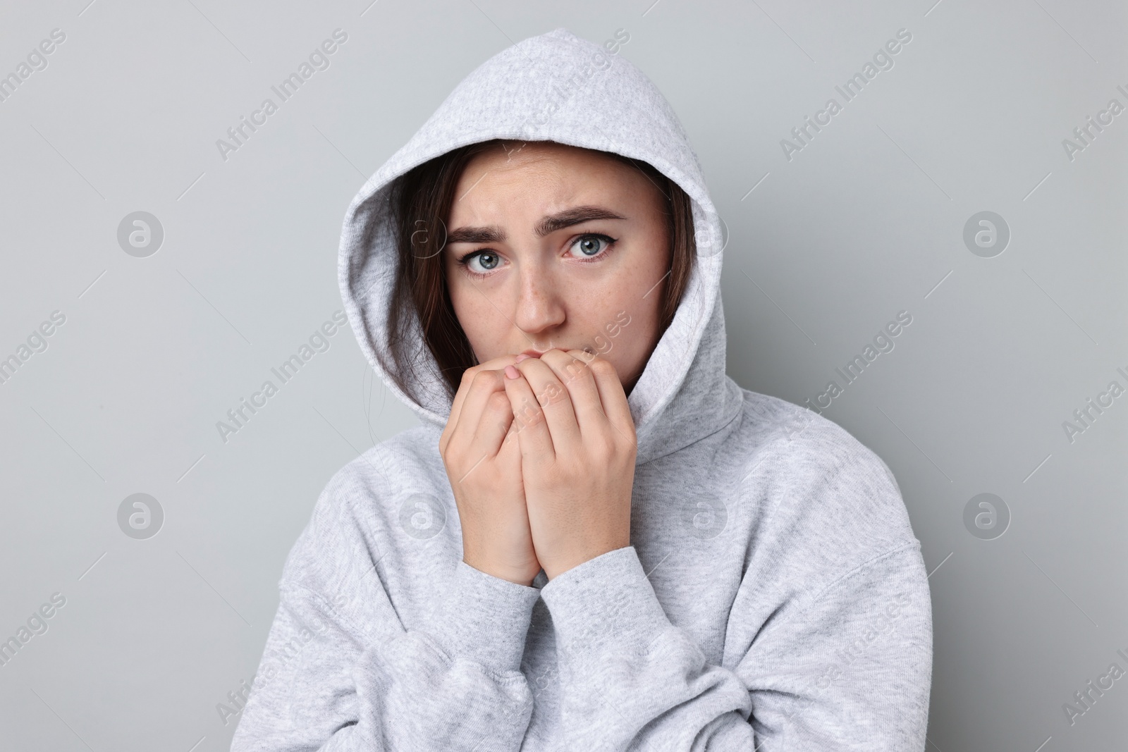 Photo of Portrait of scared woman on light background