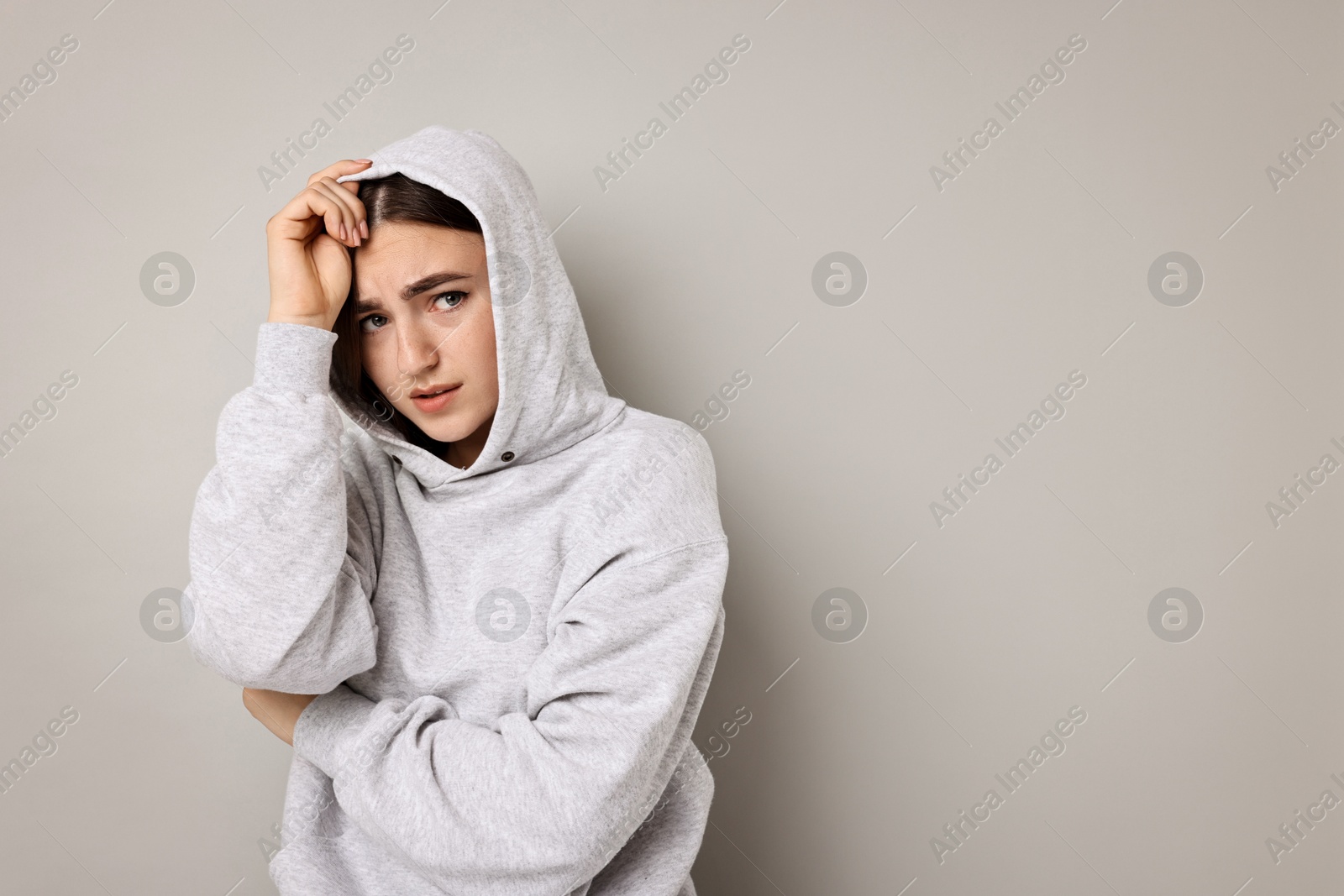 Photo of Portrait of scared woman on light background. Space for text