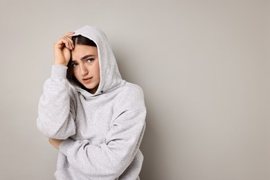 Portrait of scared woman on light background. Space for text