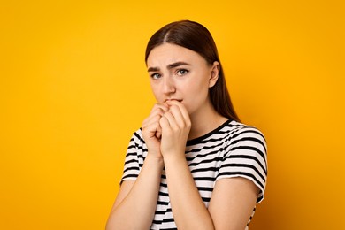 Portrait of scared woman on orange background