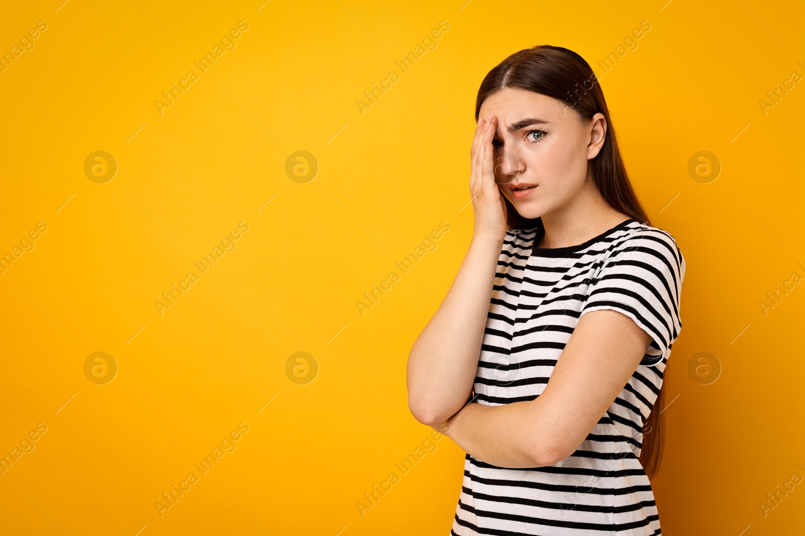 Photo of Portrait of scared woman on orange background. Space for text