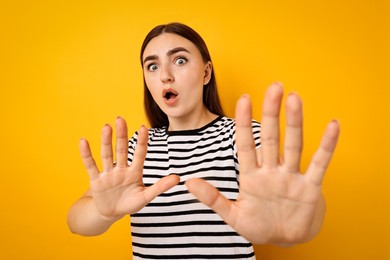 Photo of Portrait of scared woman on orange background