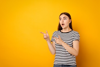 Portrait of scared woman on orange background. Space for text