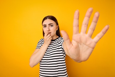 Portrait of scared woman on orange background