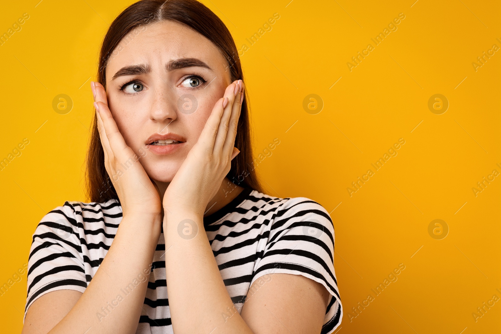 Photo of Portrait of scared woman on orange background. Space for text