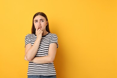 Photo of Portrait of scared woman on orange background. Space for text