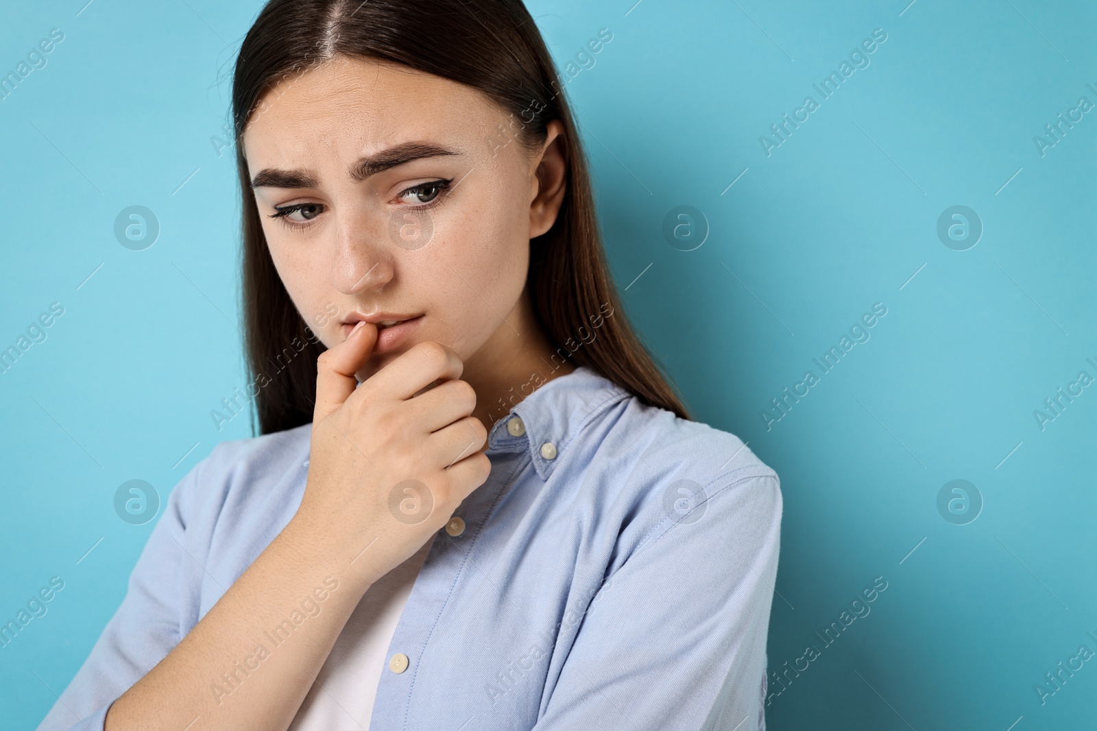 Photo of Portrait of scared woman on light blue background