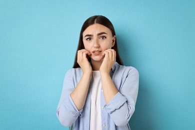 Photo of Portrait of scared woman on light blue background