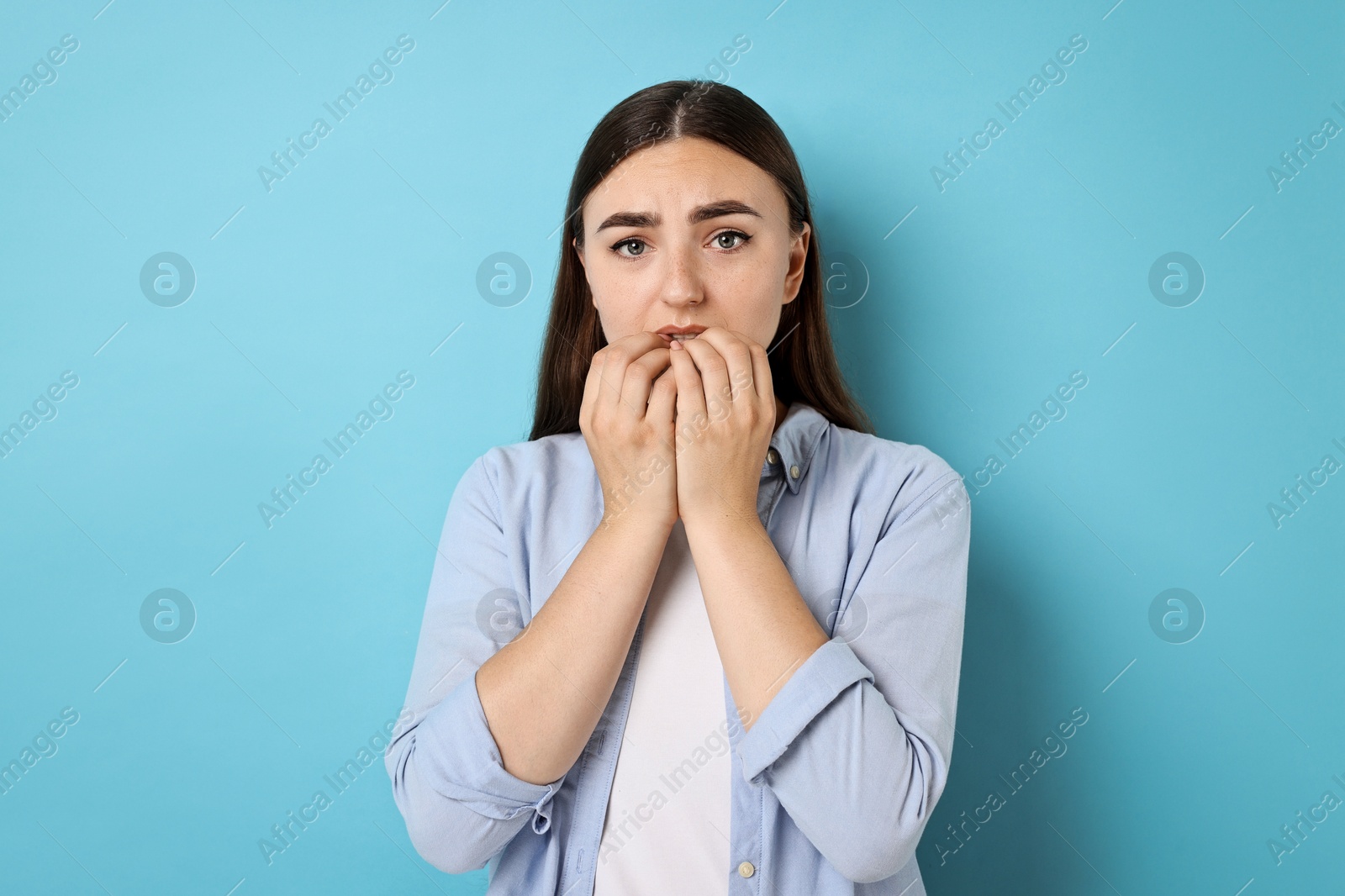 Photo of Portrait of scared woman on light blue background