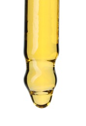 Photo of Dripping essential oil from pipette on white background