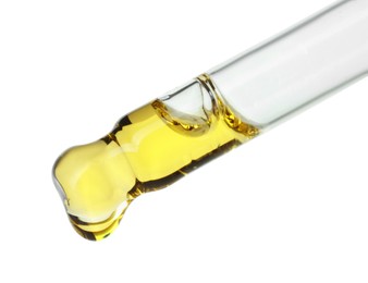 Photo of Dripping essential oil from pipette on white background