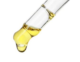 Photo of Dripping essential oil from pipette on white background