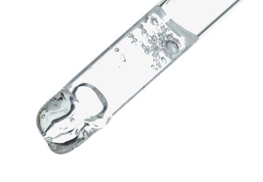 Photo of Dripping cosmetic serum from pipette on white background