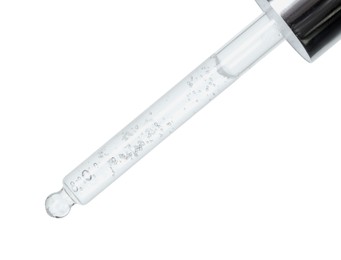 Dripping cosmetic serum from pipette on white background