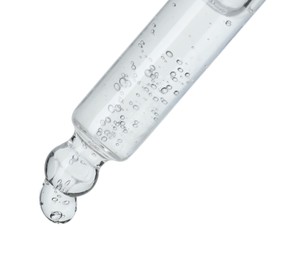 Dripping cosmetic serum from pipette on white background