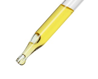 Dripping essential oil from pipette on white background