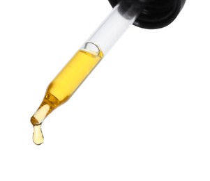 Dripping essential oil from pipette on white background