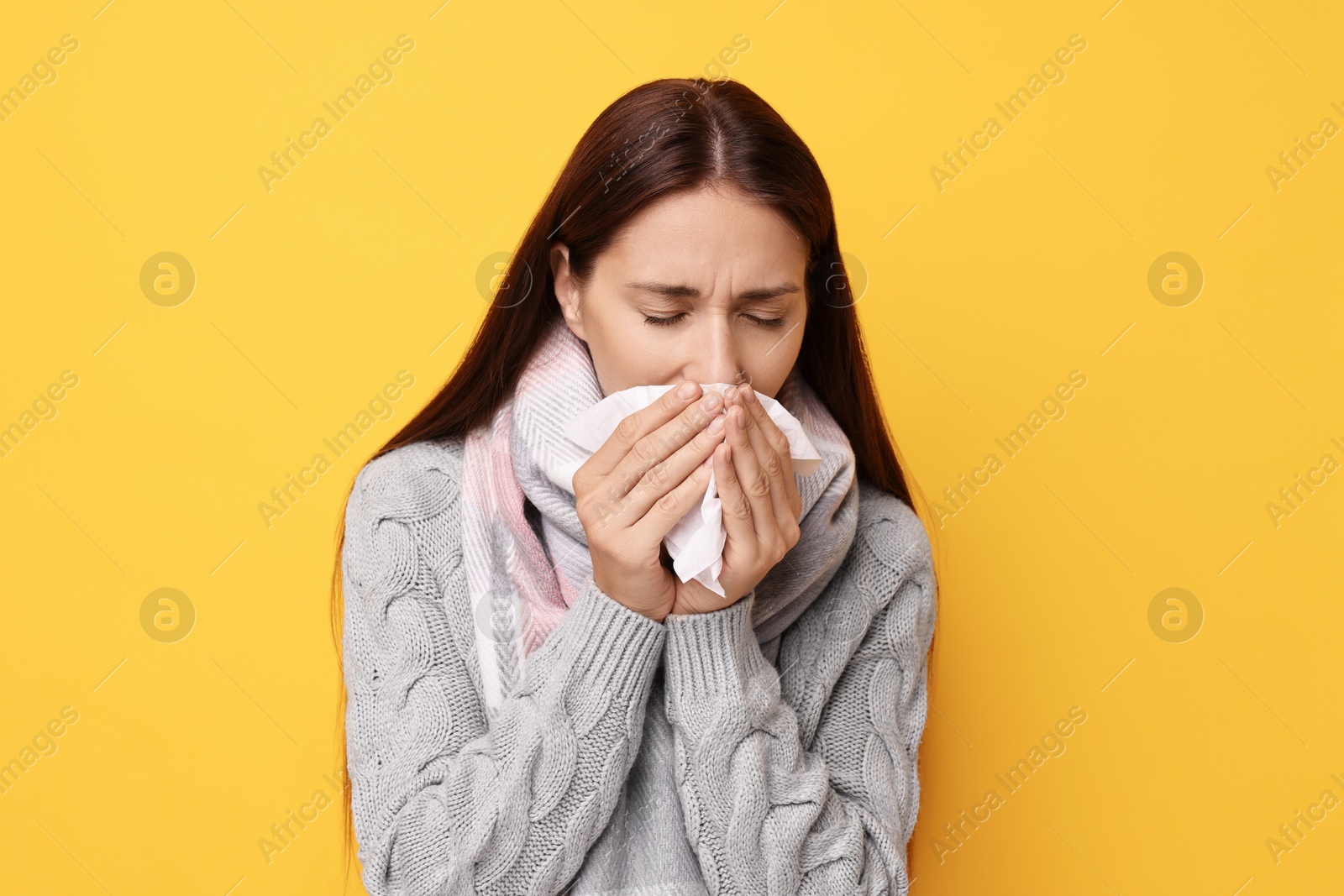 Photo of Sick woman with tissue on orange background. Cold symptoms