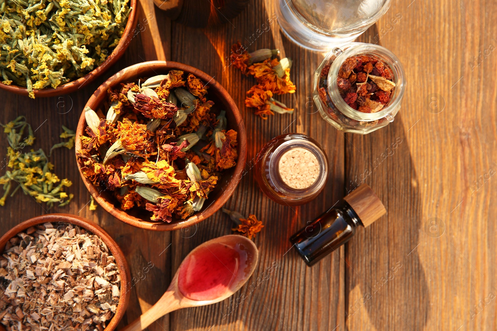 Photo of Different tinctures and ingredients on wooden table, flat lay