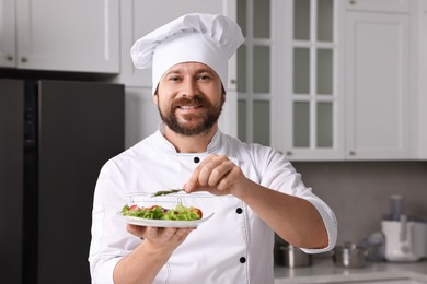 Photo of Professional chef decorating delicious dish with rosemary in kitchen