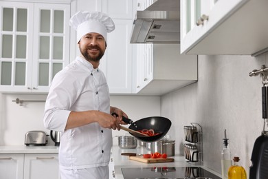 Professional chef cooking delicious food in frying pan indoors