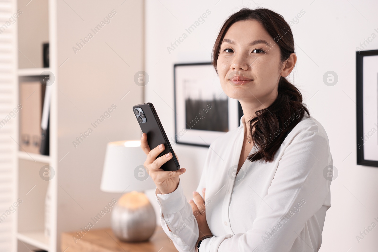 Photo of Portrait of beautiful businesswoman with smartphone in office. Space for text