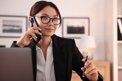 Photo of Beautiful businesswoman talking on smartphone in office